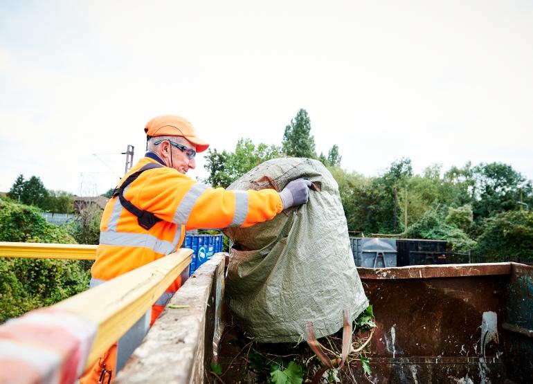 Man throwing green waste